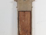 a small wooden object hanging on a white wall