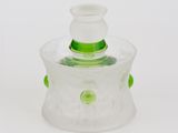 récipient en verre transparent muni d'un couvercle vert, posé sur une surface blanche