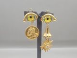 an image of a pair of earrings with a gold eye and a coin