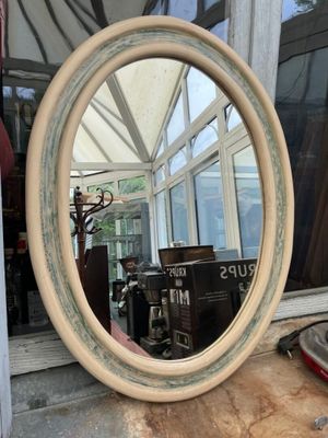 a mirror sitting on a window sill in front of a window