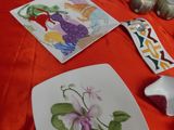 many plates and bowls on a table with a red table cloth