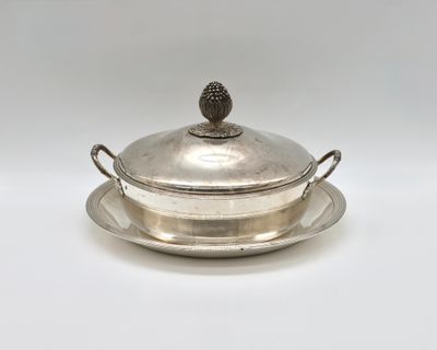 an antique silver plate with a lid and a bowl on it