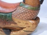 a wooden horse that is sitting on a white surface