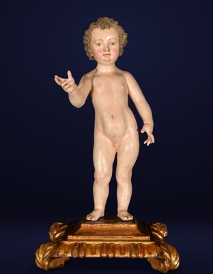 an antique figurine of a child on a pedestal