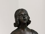 buste en bronze représentant une femme en robe noire, assise sur une étagère blanche