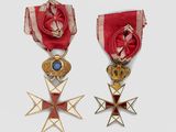 two medals and a cross are on display on a white surface