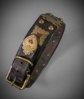 a close up of a black leather bracelet with gold and red accents