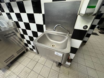 a stainless steel sink in a black and white checkered kitchen