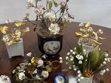 a table with a bunch of flowers and vases on it