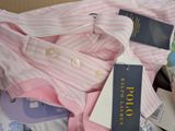 a pink and white striped shirt with a blue tag on it