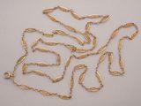a close up of a bunch of gold chains on a white surface