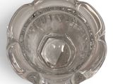a glass ashtray on a white surface with a white background