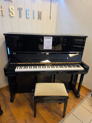 a piano in the corner of a room with a stool