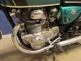 a green motorcycle parked in a garage with a blue wall in the background
