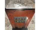 a metal box sitting on the sidewalk with a yellow button