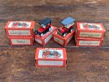 quatre petites boîtes rouges contenant des jouets assortis, posées sur une table en bois