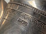 a large silver vase sitting on top of a table