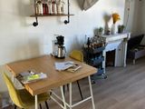 a wooden table with two yellow chairs in the middle of the room