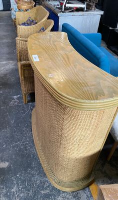 several wicker chairs are lined up in a row in a warehouse