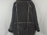 a black leather jacket hanging on a hanger on a white wall