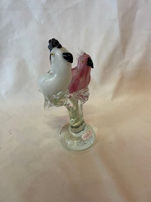 une figurine représentant deux oiseaux perchés sur un vase en verre