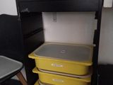 une pile de récipients en plastique posée sous un bureau