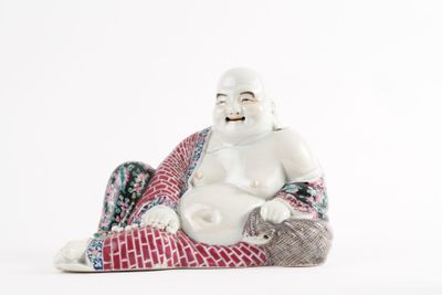 a figurine of a laughing buddha sitting on a blanket
