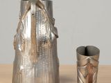 a silver vase and a silver cup sitting on a table