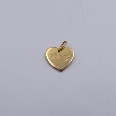 un pendentif en forme de cœur en or sur lequel est inscrit le mot « love »