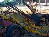 a yellow tractor that is sitting in the grass