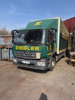 un camion vert garé sur un parking