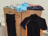 une boîte en carton avec des vêtements posés dessus, dans une pièce