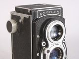 a black and silver camera sitting on a white surface
