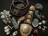 une table noire sur laquelle sont posés des bijoux et un téléphone portable