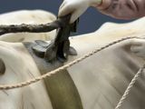 a hand that is holding a rope to a statue