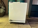 a white refrigerator sitting on a cart in a room