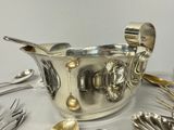 a silver bowl with spoons, forks and spoons on it
