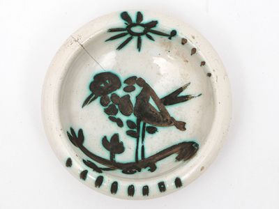 a plate with a bird on it on a white surface