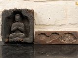 une petite statue de Bouddha assis dans un bloc de pierre