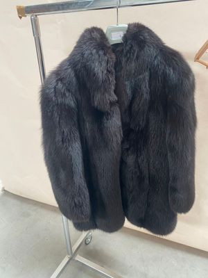 un manteau de fourrure noir suspendu à un porte-manteau dans une pièce