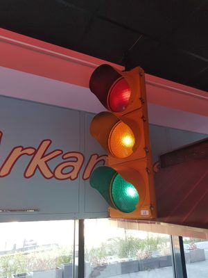 a traffic light hanging from the ceiling in front of a store