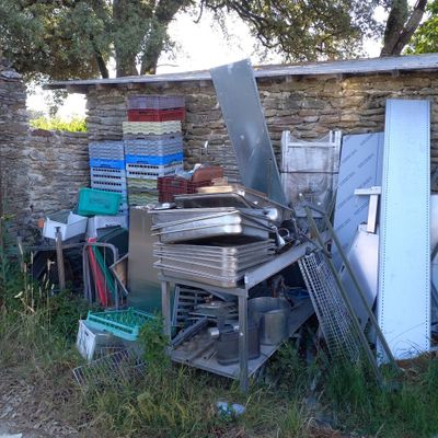 un tas de vieilleries devant un mur de pierre