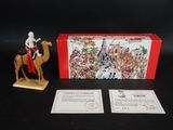 une image représentant une figurine d'un homme à cheval à côté d'une boîte de cartes