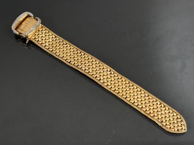 a close up of a gold watch on a black surface