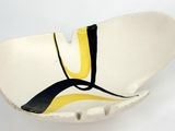 a white bowl with a yellow and black design on it