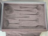 several spoons are in a box with a cloth cover