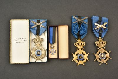 trois médailles et un livre sont posés côte à côte sur une table