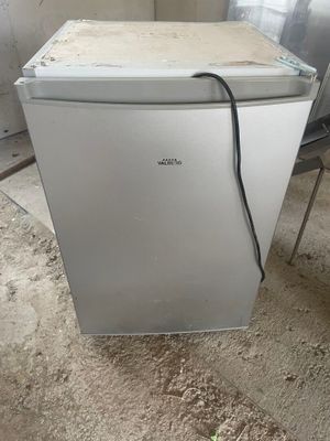 a small refrigerator that is sitting in the middle of a room