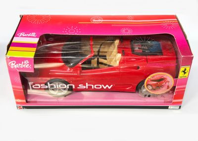 une petite voiture rouge qui se trouve dans une boîte rose