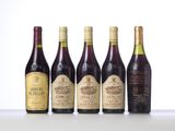 four bottles of wine are lined up on a table